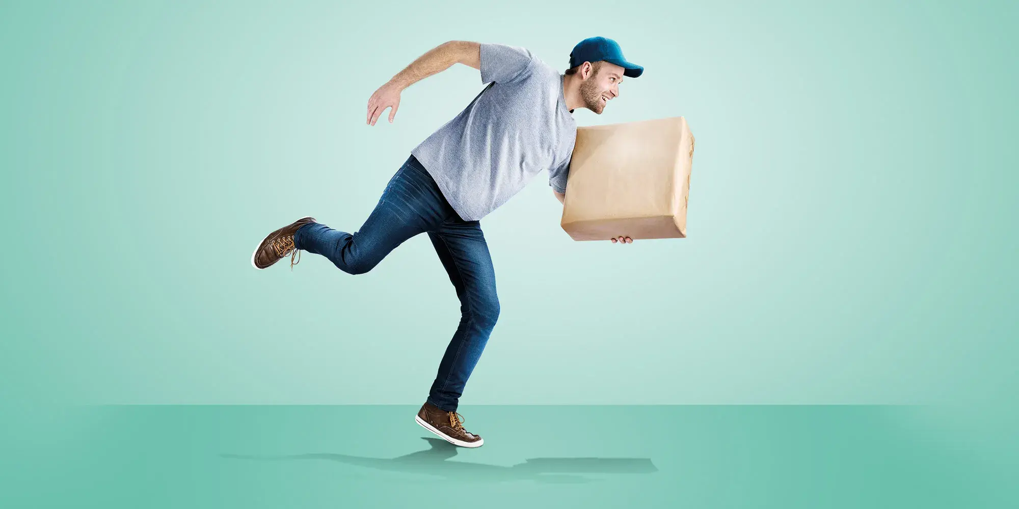 Lieferbote im Laufschritt mit Paket in der Hand